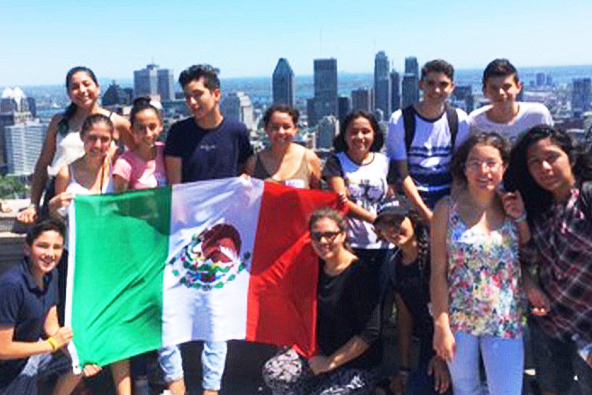 Alumnos con bandera de México sobre edificio